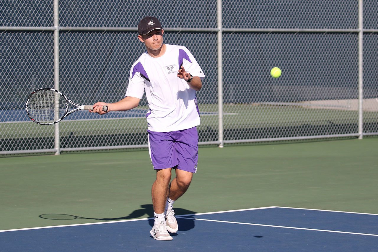 JJ Mitchell returns a shot in his win in first singles. (Photo by John Fisken.)