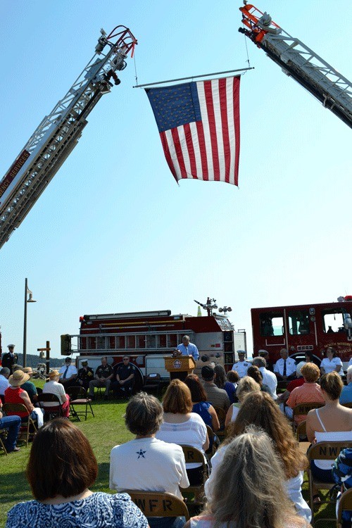 An American flag waves in the breeze as Oak Harbor Mayor Jim Slowik speaks to an audience gathered for the 9/11 memorial service Sunday afternoon.