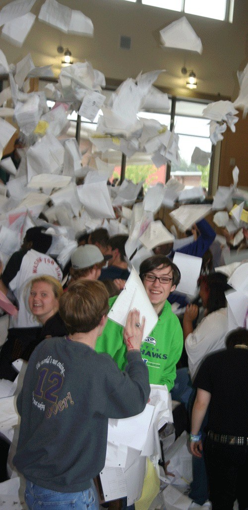 Oak Harbor High School senior David Punch gets in the middle of the paper explosion during the senior paper toss Thursday.