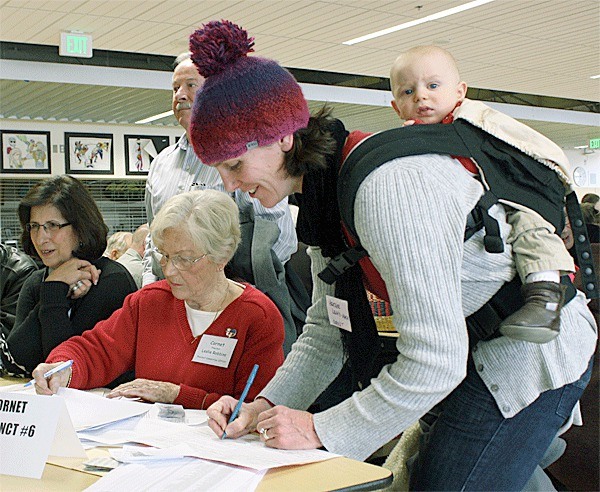 North Whidbey resident Heather Leahy-Mack votes for Rick Santorum in the straw poll at Saturday’s bustling Republican caucus at Oak Harbor High School. She and her husband brought their five children