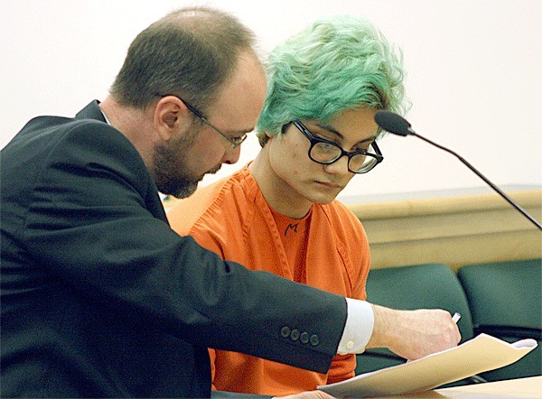 Oak Harbor resident Andrew Monroe looks over court documents with his attorney in Island County Superior Court. He pleaded guilty to third-degree assault.