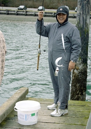 Seattle resident James Sagon is all smiles pulling four nice-sized smelt from the waters off the Cornet Bay boat dock.