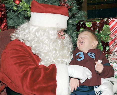 Santa and Max Fletcher have a great time together Dec. 12 as Max had his tummy tickled. Santa arrived at the Harborside Mall on the old fire truck  to a host of eager children.