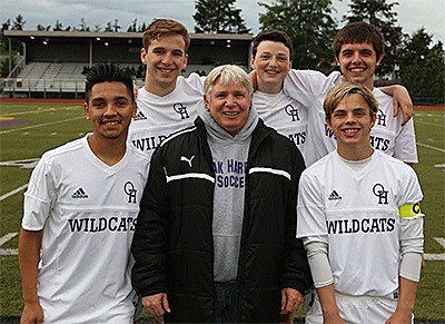 Oak Harbor soccer coach Brian Thompson is surrounded by his senior players just before their final match. Thompson is retiring after 23 years with the program.  The seniors are