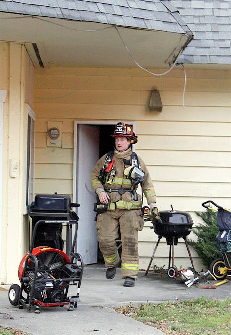 A firefighter exits a home at the intersection of Loerland Drive and Orchard Loop Wednesday afternoon after responding to a report of a fire.