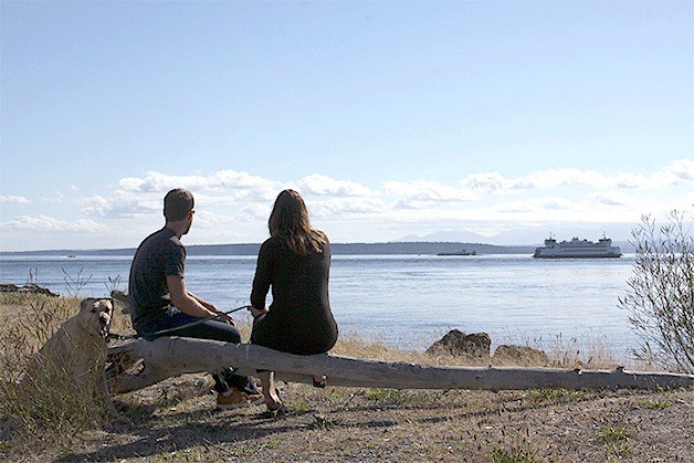 A couple takes in the view at Admiralty Inlet near the Keystone spit and the Coupeville ferry landing Wednesday night and gets a surprise. Not only did they spot a ferry arriving from Port Townsend