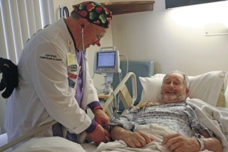 Patient  John Dyngen smiles as Blake Thompson checks his funnybone using a special stethescope with a plastic ear attached.