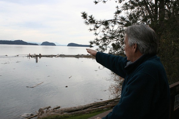 Roger Baker shows the view off his back deck of Ala Spit and the area that has become dangerous for fishermen and others who have tried to wade across it.