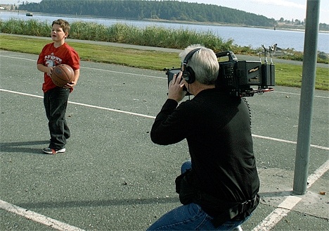 Aust helps Gonzales adjust his microphone before the shoot at Windjammer Park