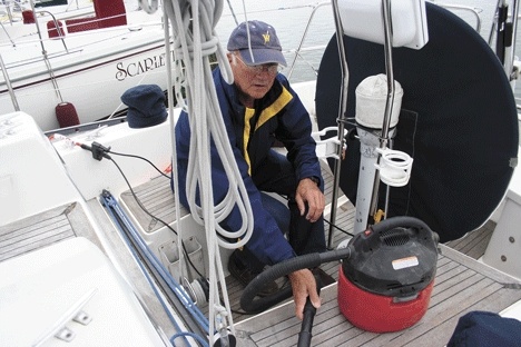 Byron Skubi does a bit of cleanup work after some sanding on the stern area of his boat