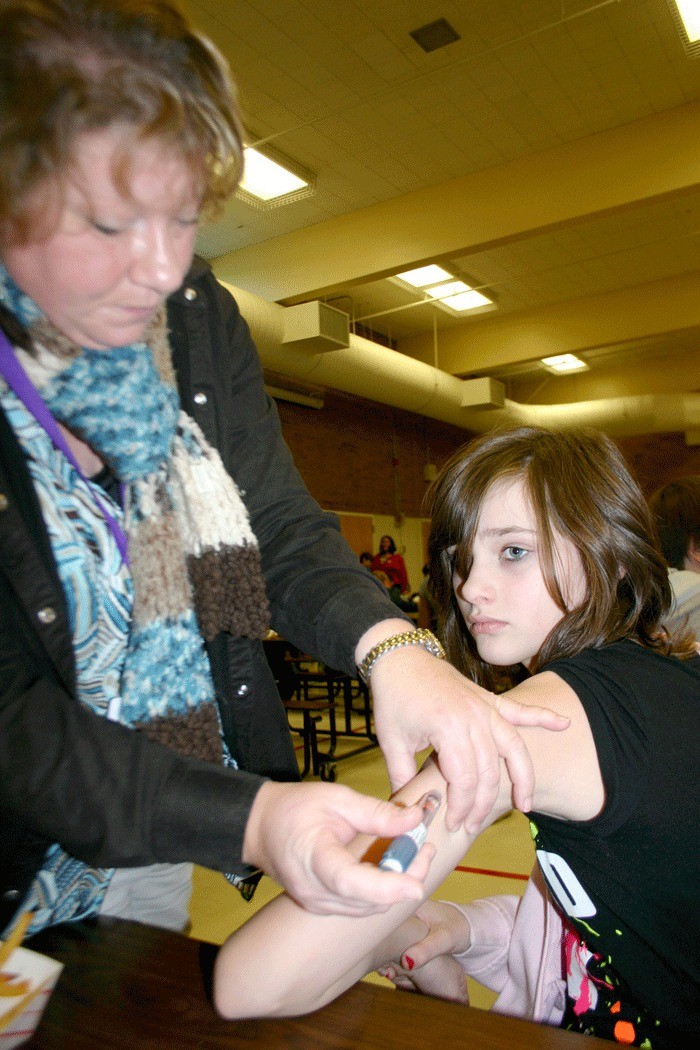 Oak Harbor School District nurse Robbin White administers an insulin shot to diabetic student Brenna Sherman during lunch at Oak Harbor Middle School.