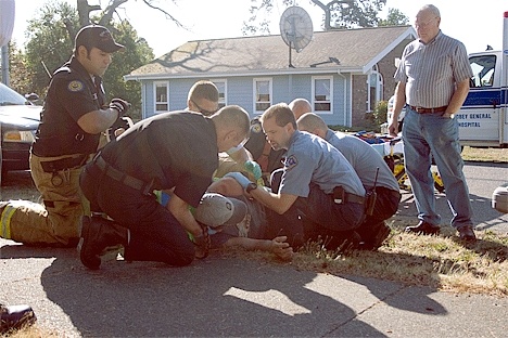 EMTs and Oak Harbor Firemen move Bryan Street onto a backboard for transport to Whidbey General Hospital.