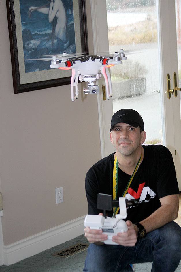 Paul Skinner demonstrates how a camera-equipped drone hovers around indoors in Oak Harbor. He and his brother launched a new aerial media company.