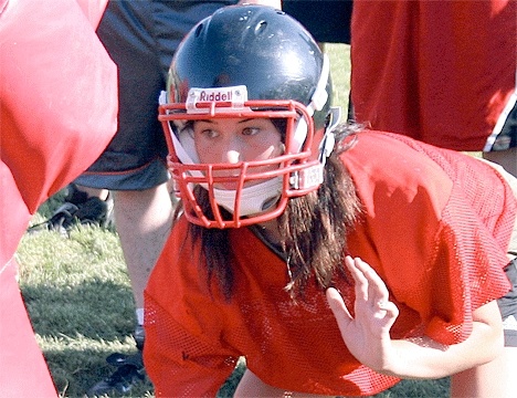 In a three-point stance with her eyes locked on the target