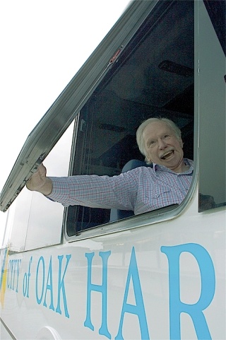 Oak Harbor Senior Center bus driver Tom Luehr cracks a smile while onboard the center’s brand new bus.