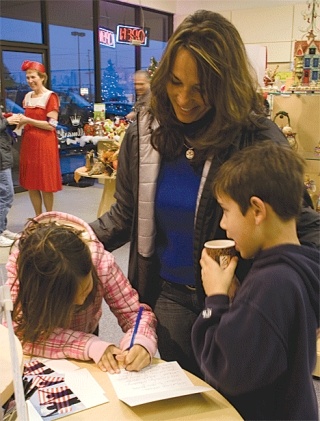 Cyndi Whelpley and her daughter Brooke sign a holiday card thanking U.S. troops for their service. Hallmark will send the cards in December.