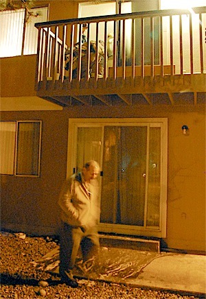 Oak Harbor Fire Department firefighters investigate the remnants of a fire that broke out on a deck at Villa Marina Apartments Saturday as complex owner Joe Franssen walks underneath.