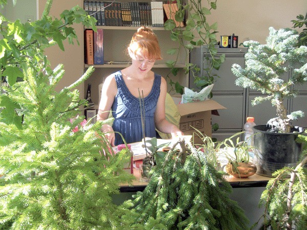 English teacher Maya Kilmer begins organizing her desk for the upcoming year.  Kilmer has always tried to incorporate the outdoors into her classroom and this year is decorating her space with small trees.