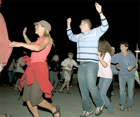 Party-goer Ben Olson jumps into a conga line during a Race Week party at the Seaplane Base Marina