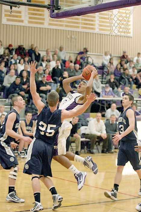 Oak Harbor’s Mike Washington Jr. (white uniform) led Oak Harbor with 14 points.