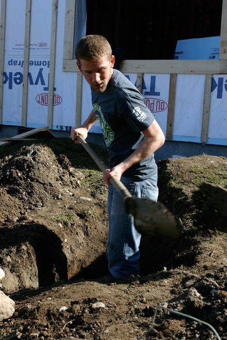 Moorhead State University student Joshua Berggren digs for the sewer main that will serve the home being built for a family in need. He spent his Spring Break volunteering for Habitat for Humanity.