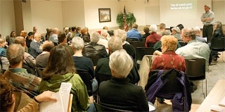 A crowd of about 50 listen to Larry Kalb’s speech on health care reform at Sunday’s meeting