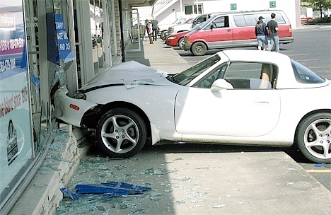 A white Mazda Miata crashes through the front of a Pioneer Way building Saturday afternoon.