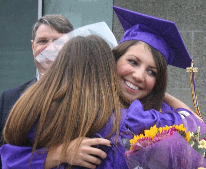 Shannon Neilon hugs Maura McKole after graduation. See A13 for coverage of the Wildcat ceremony.