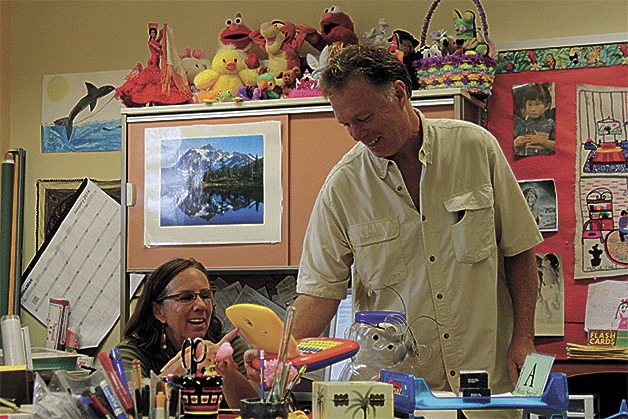 Olympic View Elementary School kindergarten teachers Susan Stockfeld and husband Jeff Hume share a laugh while observing a child’s play laptop in Stockfeld’s classroom.