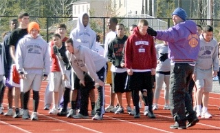 Oak  Harbor track coach Jay Turner gets team members organized for a warm-up drill.