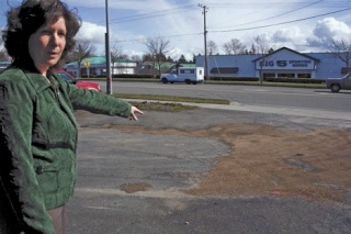 WorkSource employee Anne Hallam points to an oil spill in the parking lot where Island County Sheriff’s Deputy Brent Durley crashed Friday night.