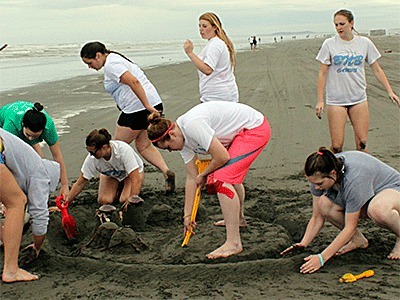 Members of the Coupeville High School girls basketball team work on a sand castle and team bonding at team camp this summer.