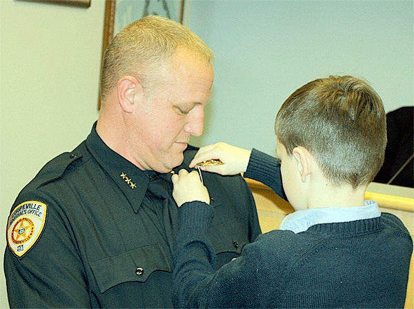 Andrew Davenport pins a badge on his father