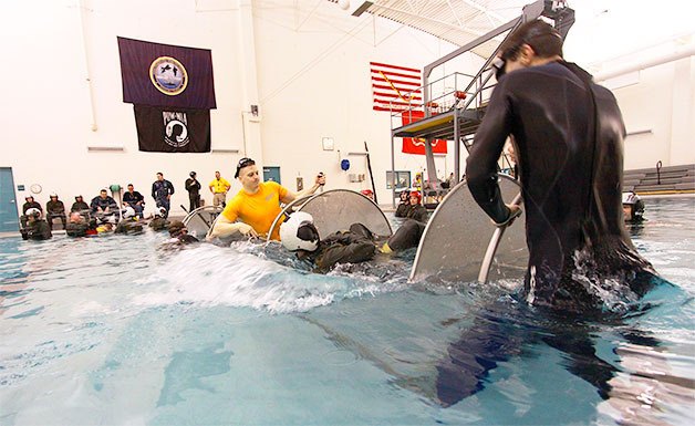 Aviation crews of Army helicopters train using the Modular Swallow Water Egress Trainer to practice getting out of a seat and harness while upside down submerged in water at Whidbey Island Naval Station’s Aviation Survival Training Center.