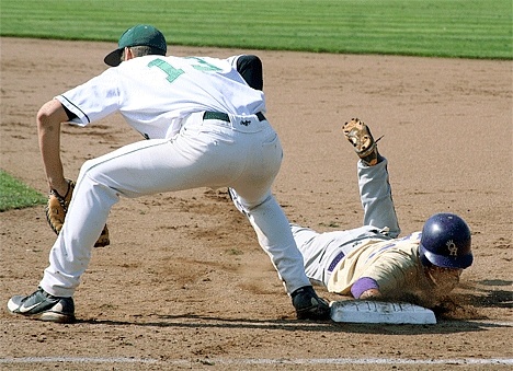 Oak Harbor’s Sam Wolfe eats a face full of dirt as he dives safely back to first base on a pickoff attempt.