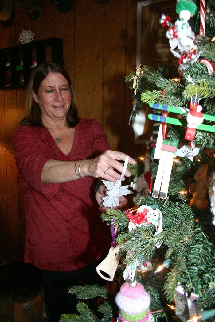 Robin Gohn hangs ornaments on her tree adorned with 25 years of handmade treasures.