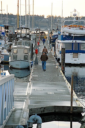 People walk along the docks at Oak Harbor Marina. The city council last week approved a plan to abandon a 5 percent rate increase scheduled to go into effect next year in the hopes of improving occupancy and making the facility more competitive.