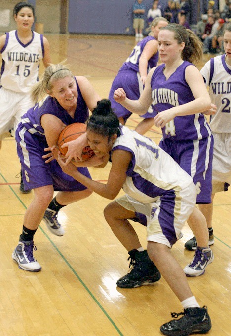 Oak Harbor’s Jessica Denmon (white uniform) fights for a loose ball with Lake Stevens’ Megan Warbis.