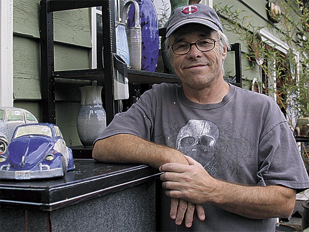 Dan Ishler stands in front of his art studio on his property in Oak Harbor.