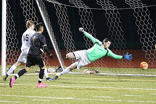 Oak Harbor's Kurtis Zylstra (16) punches a goal by the Lynnwood keeper in Friday's match.