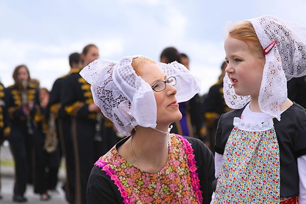 Tammi Fisher and her daughter Makenna Fisher are dressed in Dutch attire as they wait for the start of the Holland Happening grand parade Saturday in Oak Harbor. Makenna’s job was to hand out tulips. See more Holland Happening photos on page A9.