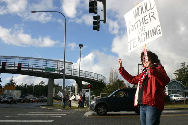 Coupeville High School teacher Barbara Ballard waves at cars during a teacher rally against state budget cuts.