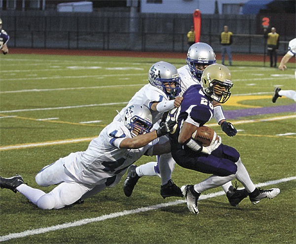 It takes three Shorewood defenders to bring down Oak Harbor's Josiah Miller in the Wildcats' win Friday night.