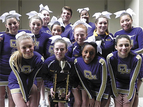 The Oak Harbor cheerleaders gather around their second-place trophy. Bottom