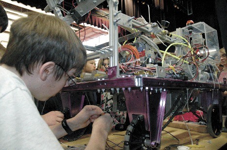 Student Jeremiah Konovaloff puts a few finishing touches on the Oak Harbor High School robot