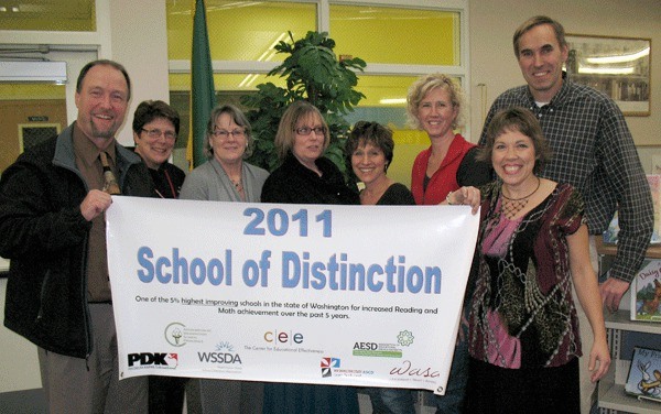 Coupeville Elementary School staff show off a banner naming the school at a 'School of Distinction.'