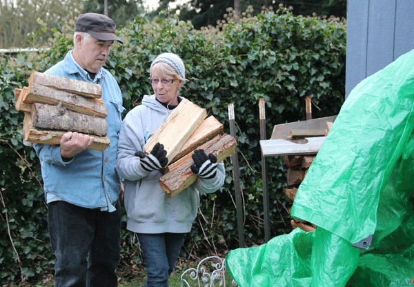 Wayne and Sallie Killebrew stack firewood for a resident of their mobile home park who is raising a great-grandchild.