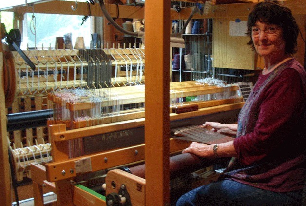 Linda LaMay weaves an alpaca/silk scarf on her 24-shaft AVL loom. Check out fiber artists’ talent at Whidbey Weavers Guild’s annual Uncommon Threads show and sale.