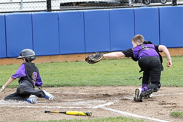 Brock Boyer slides by the sweeping tag of the Anacortes catcher for North Whidbey's first run Saturday.