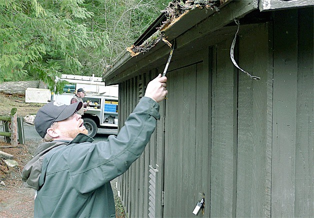 Deception Pass State Park ranger John Whittet pries a wooden gutter off a building before replacing it. Park staff have been busy in recent years completing a number of improvement projects at the Cornet Bay Retreat Center.